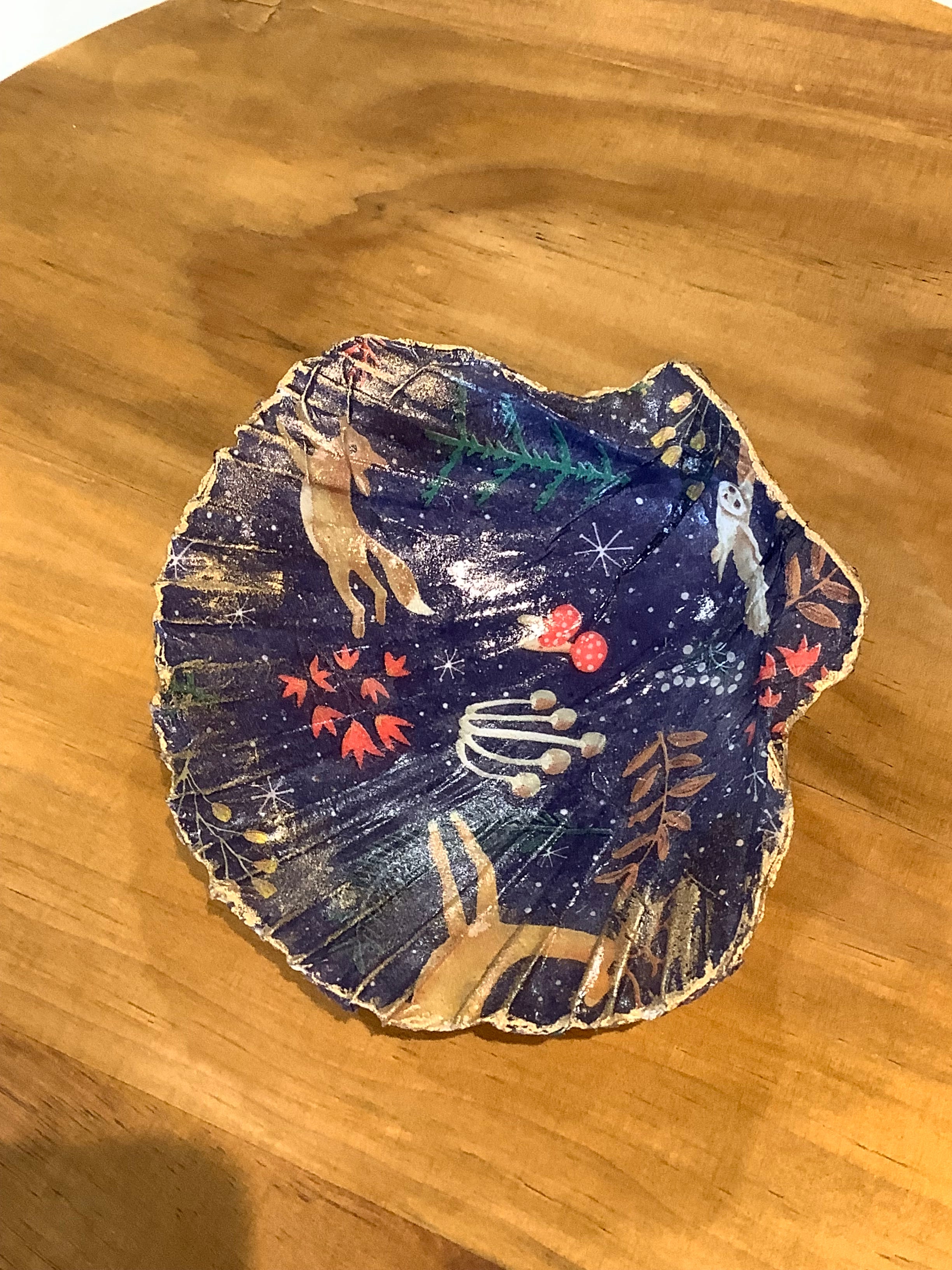 Scallop shell with a fox, dee and barn owl and toadstools on a navy background