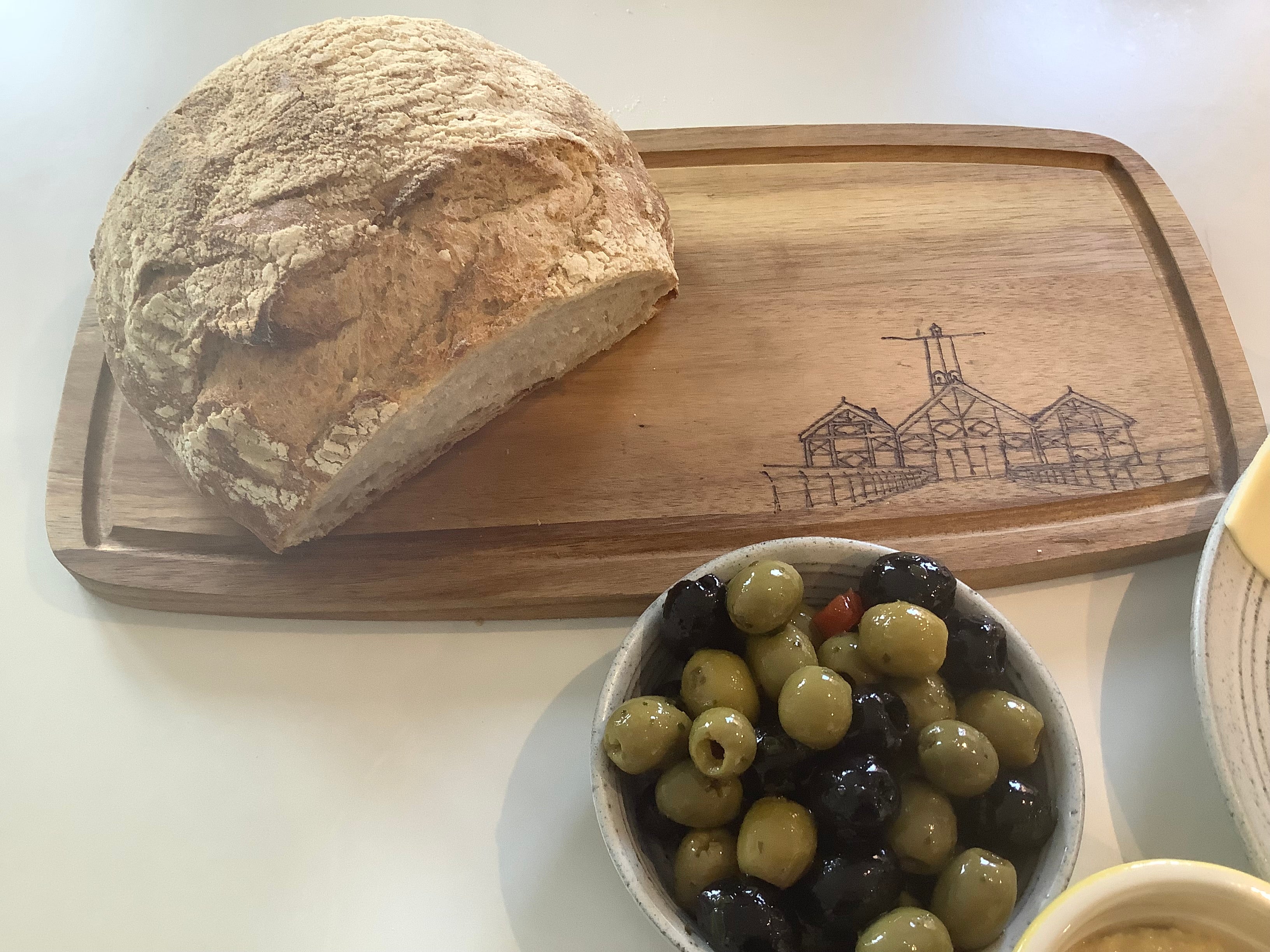 Small acacia wood serving board with hand-burned Saltburn Pier amusements pyrography illustration, styled with snacks perfect for dining or gifting