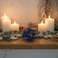 Hand-decorated navy blue scallop shell trinket dish with woodland animals at night design, displayed on a rustic shelf with candles and coastal decor